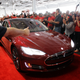 Tesla workers cheer on one the first Tesla Model S cars sold during a rally at the Tesla factory in Fremont, Calif., Friday, June 22, 2012. The first mass-market sedans offered by electric car maker Tesla are now on the road.
